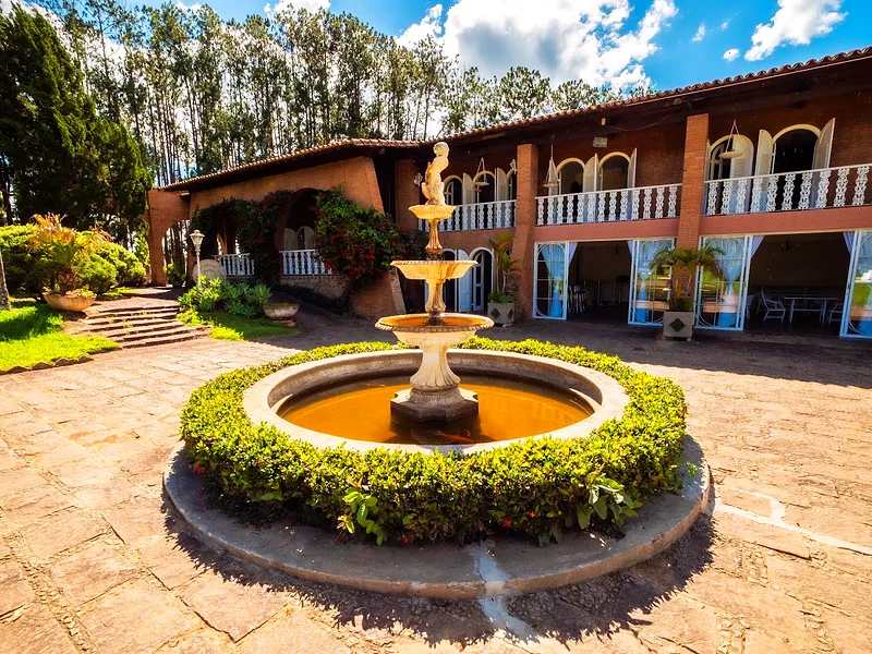 Pátio da Fazenda Vintém com fonte central e a casa ao fundo