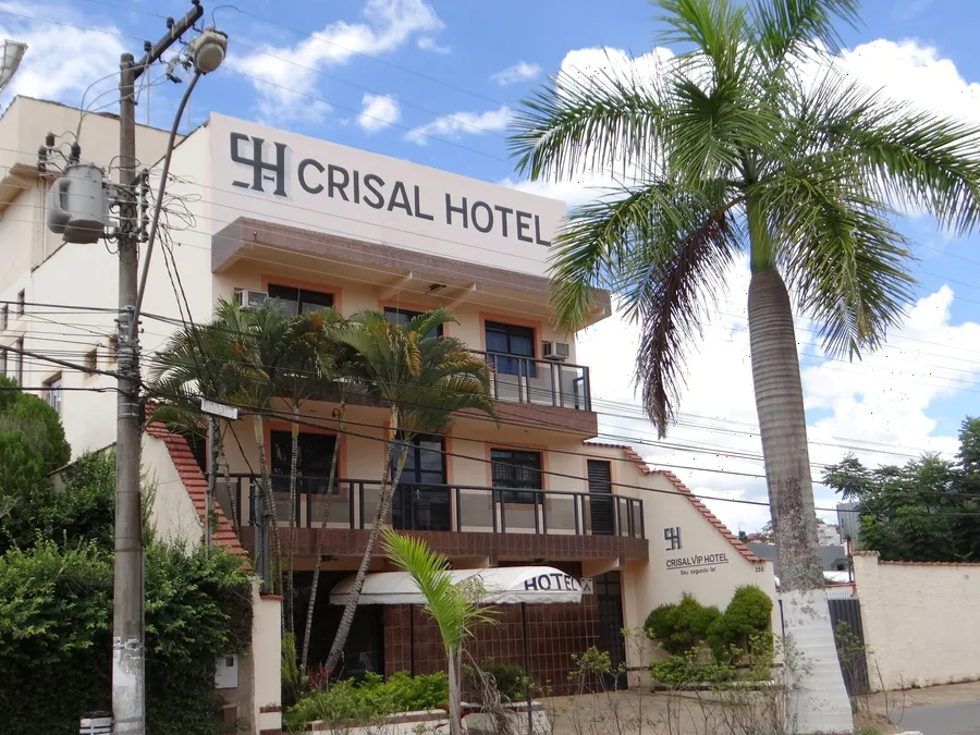 Fachada do Crisal Hotel, com palmeiras na entrada