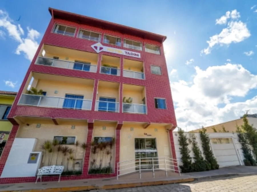 Fachada do Hotel Tadini, prédio vermelho com varandas